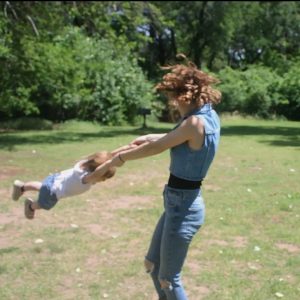 mother swinging toddler around in a circle